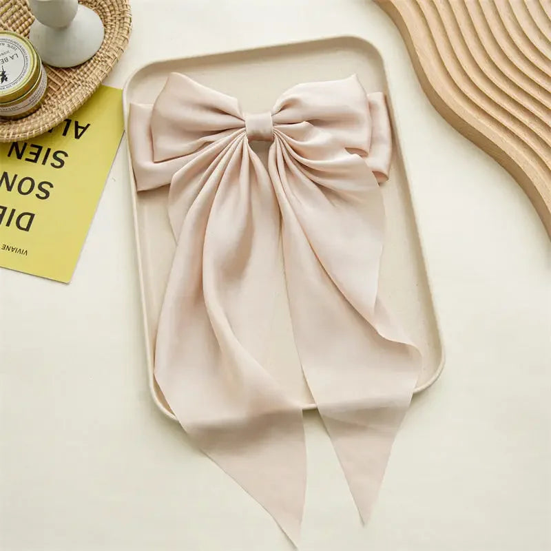 Elegant satin bow hair clip with strong hold and soft feminine style.