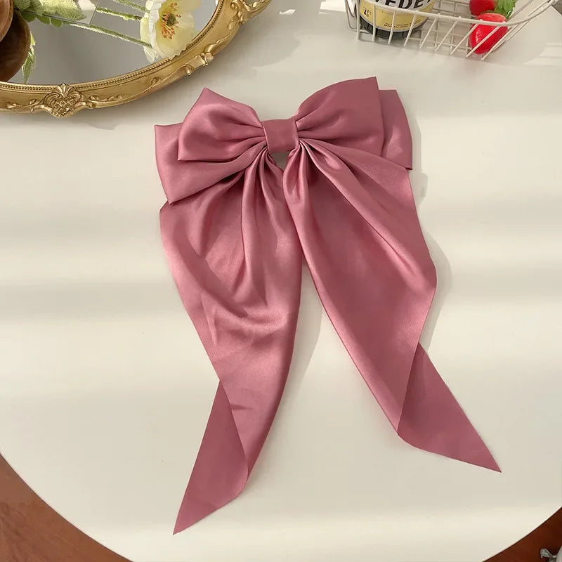Elegant satin bow hair clip with strong hold and soft feminine style.